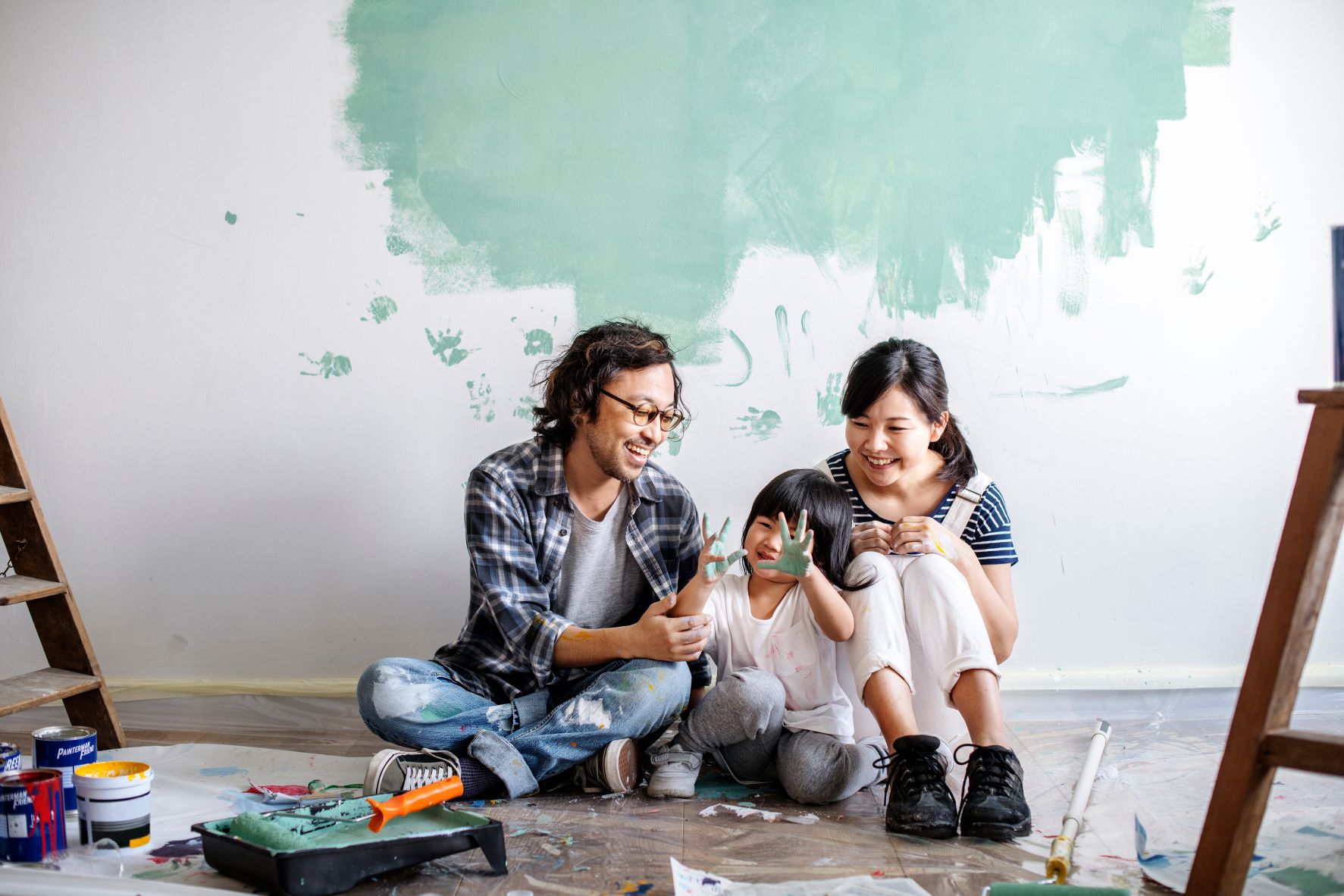 Family sitting in front of partially painted wall sm